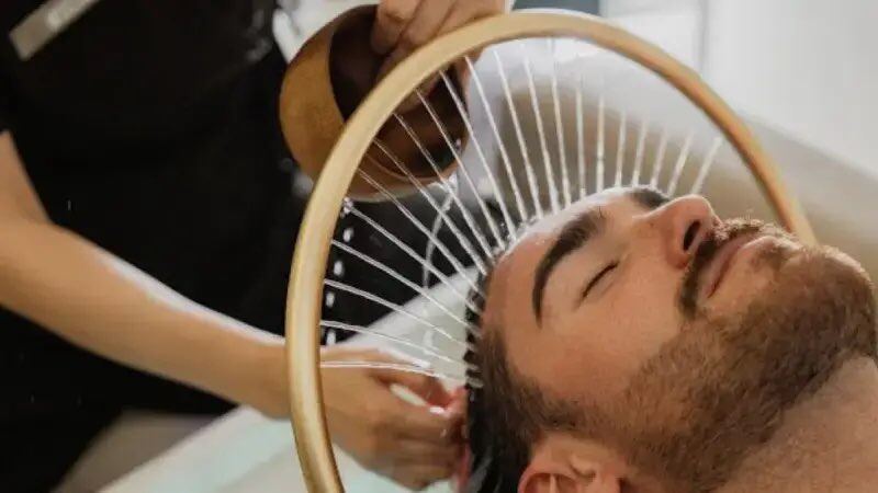 Man receiving a scalp treatment at a head spa basin on Long Island