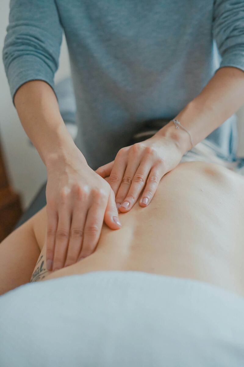 Therapist hands performing a relaxing back treatment during body care