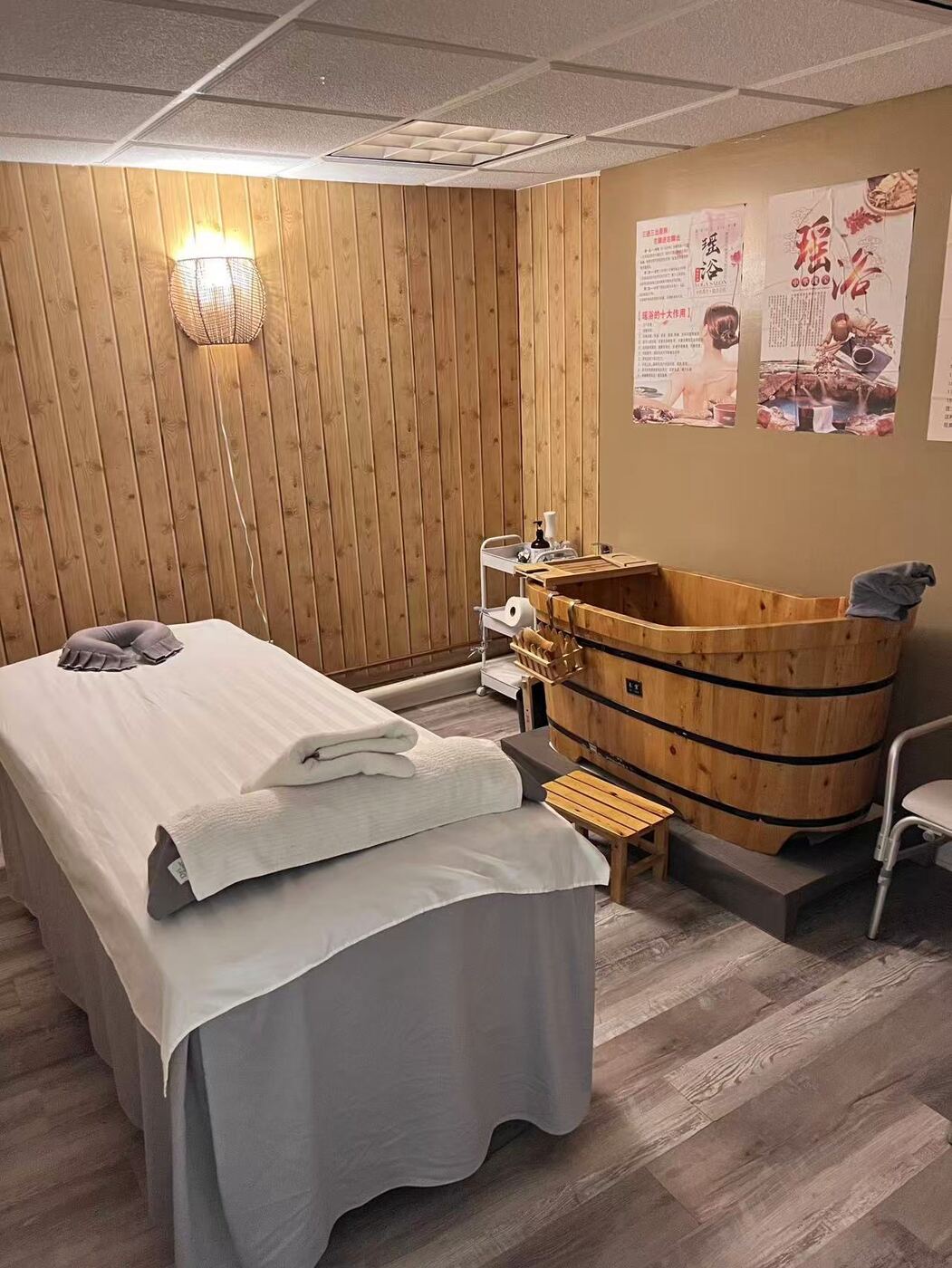 Wooden herbal soaking tub beside a treatment bed at Eastern Head Spa Mineola